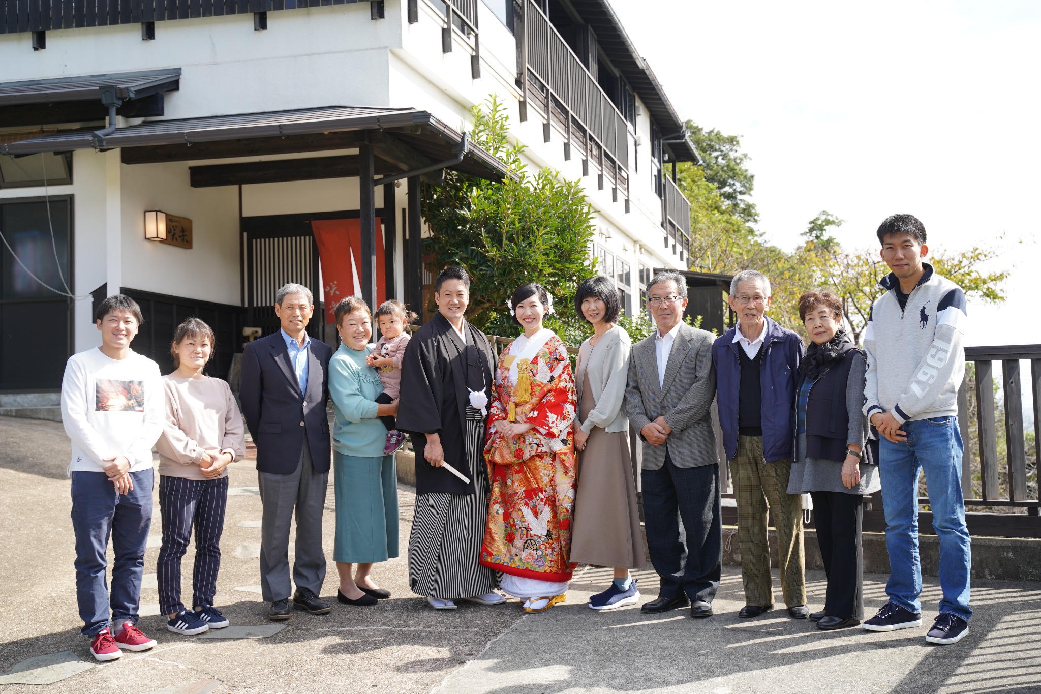 咲楽の前で家族に囲まれた和装の新郎新婦